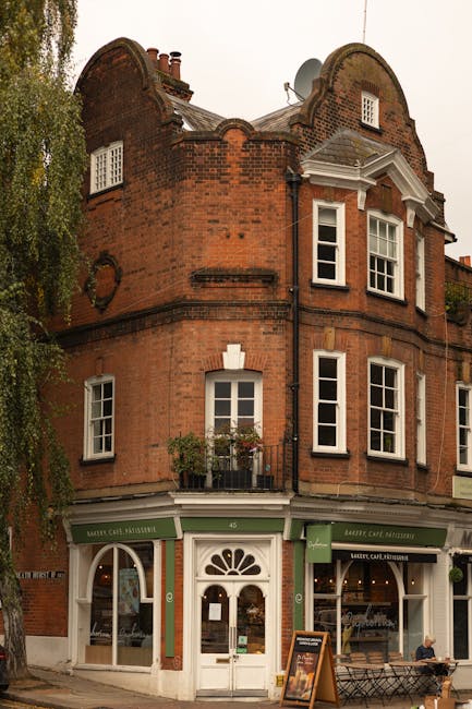 A panoramic view of a densely packed residential area in Hampstead, displaying multiple rows of terraced houses and apartment buildings with red brick facades, white window frames, and tiled roofs. Th